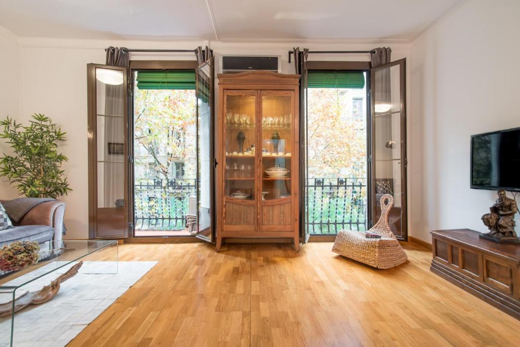 巴塞罗那Art Nouveau Apartment的客厅设有木门和窗户。