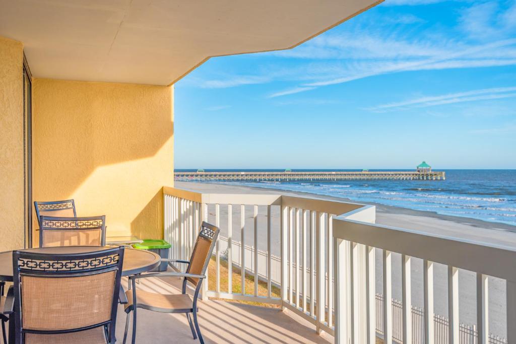 富丽海滩220 Charleston Oceanfront Villas Dolphin View的一个带桌椅的海景阳台