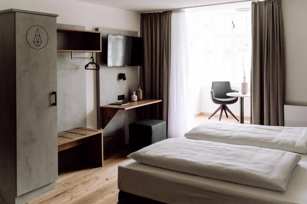 AmerangDAS STEIN的一间卧室配有一张床、一张书桌和一个窗户。