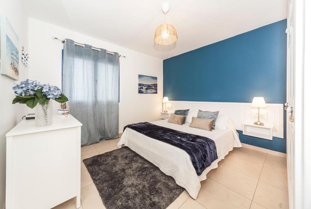 宏达海滩Luxury Suite Sea Front III的一间卧室设有一张蓝色墙壁的大床