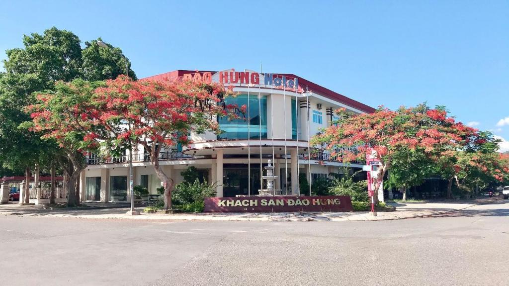 Lao BaoĐào Hùng Hotel的街道前有花树的建筑