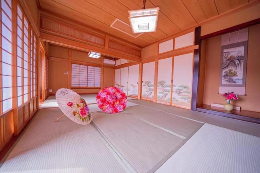 MongawaShiki no Sai的两把遮阳伞坐在房间地板上