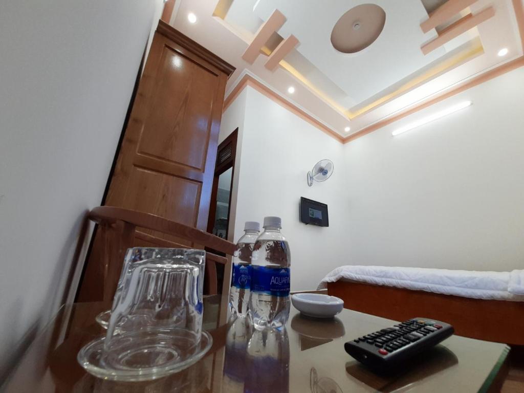 保禄Khách sạn Nguyên Long的一张桌子,上面装有一瓶水和一个遥控器