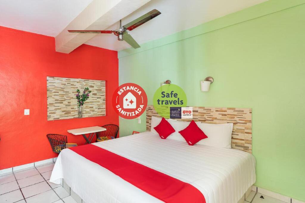 切图马尔Hotel Costa Azul的一间卧室设有一张红色和绿色的墙壁。