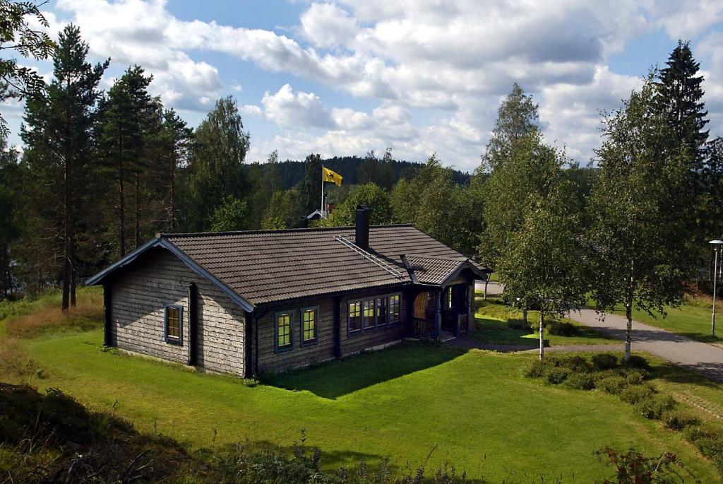 KopparbergKloten Nature Resort的草坪上的房子,上面有旗帜