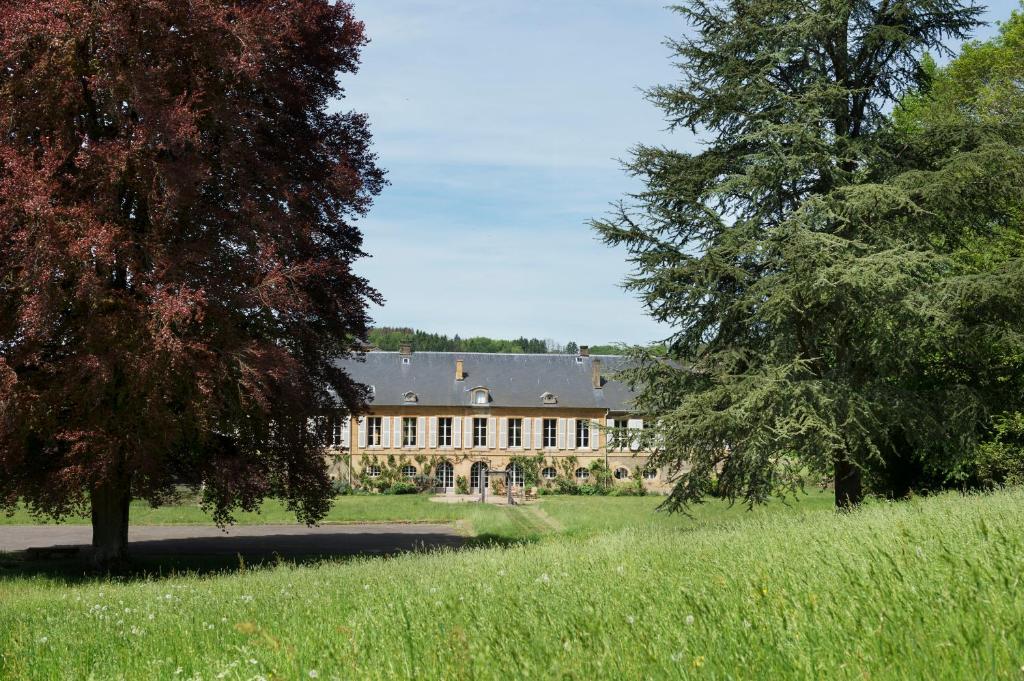 Château de Martigny的田野上树木林立的大房子