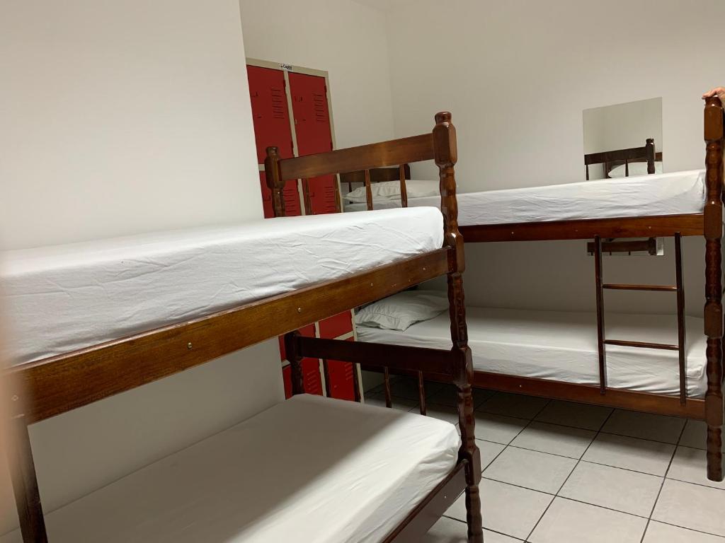 巴拉奈里奥-坎布里乌Positive Hostel的宿舍间设有两张双层床和一把椅子。
