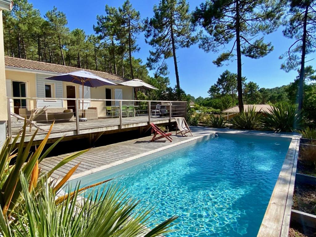 拉卡诺Villa les Mimosas with pool and fantastic views的一个带甲板和房子的游泳池