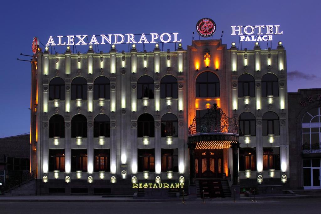 久姆里埃里桑德拉珀尔宫酒店的一座有灯的旅馆大楼,上面有标志