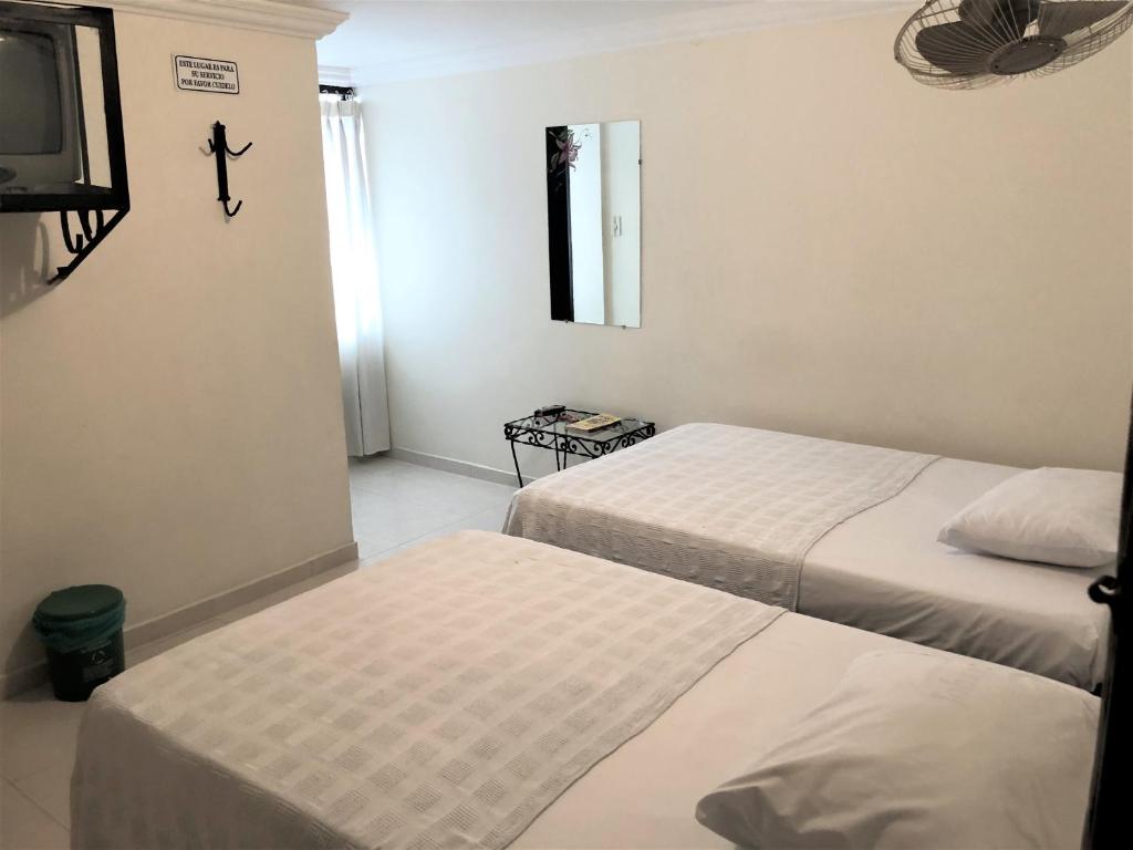 图卢阿Hotel Central Johanna的一间酒店客房,设有两张床和电视