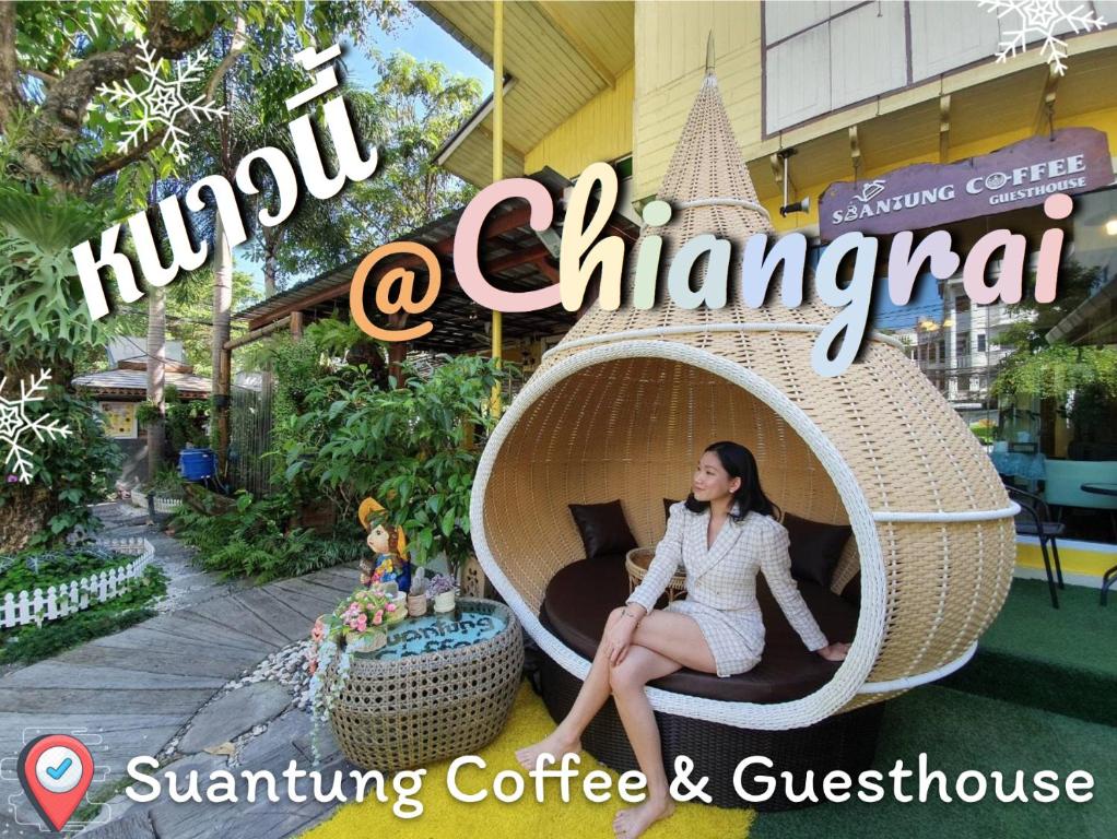 清莱SuanTung Coffee & Guesthouse的坐在建筑物前的柳条 ⁇ 上的女人