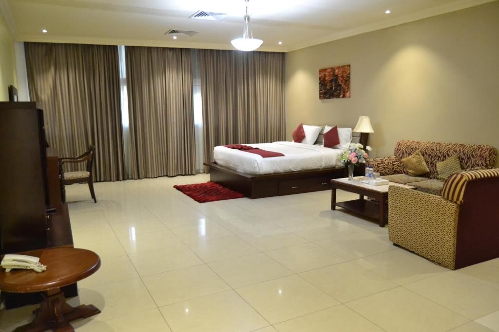 迪拜ORIENTAL CORNER HOTEL APARTMENTS LLC的酒店客房,配有床和沙发