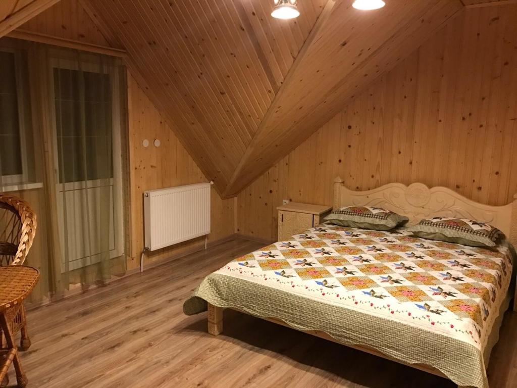 亚列姆切Писанка Плюс的木制客房内的一间卧室,配有一张床