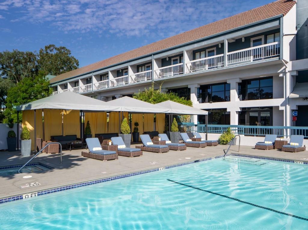 森尼维耳市多马恩酒店的一座带游泳池和椅子的酒店和一座建筑