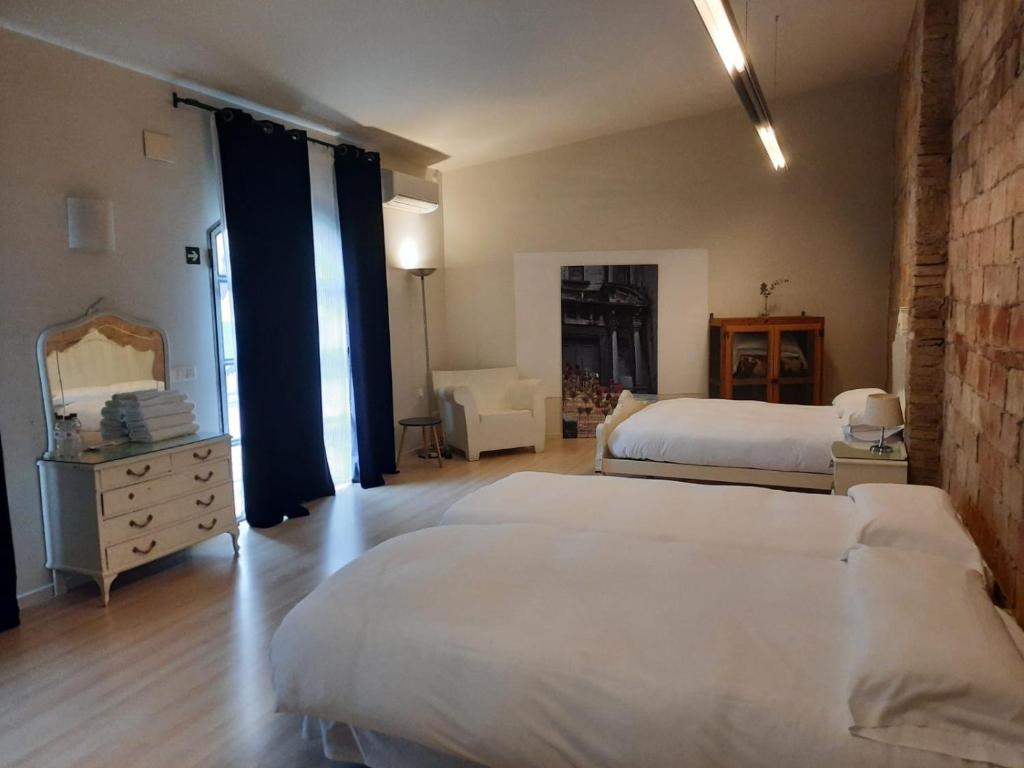 班约莱斯卡拉芙罗拉住宿加早餐旅馆的一间卧室配有两张床、一个梳妆台和镜子