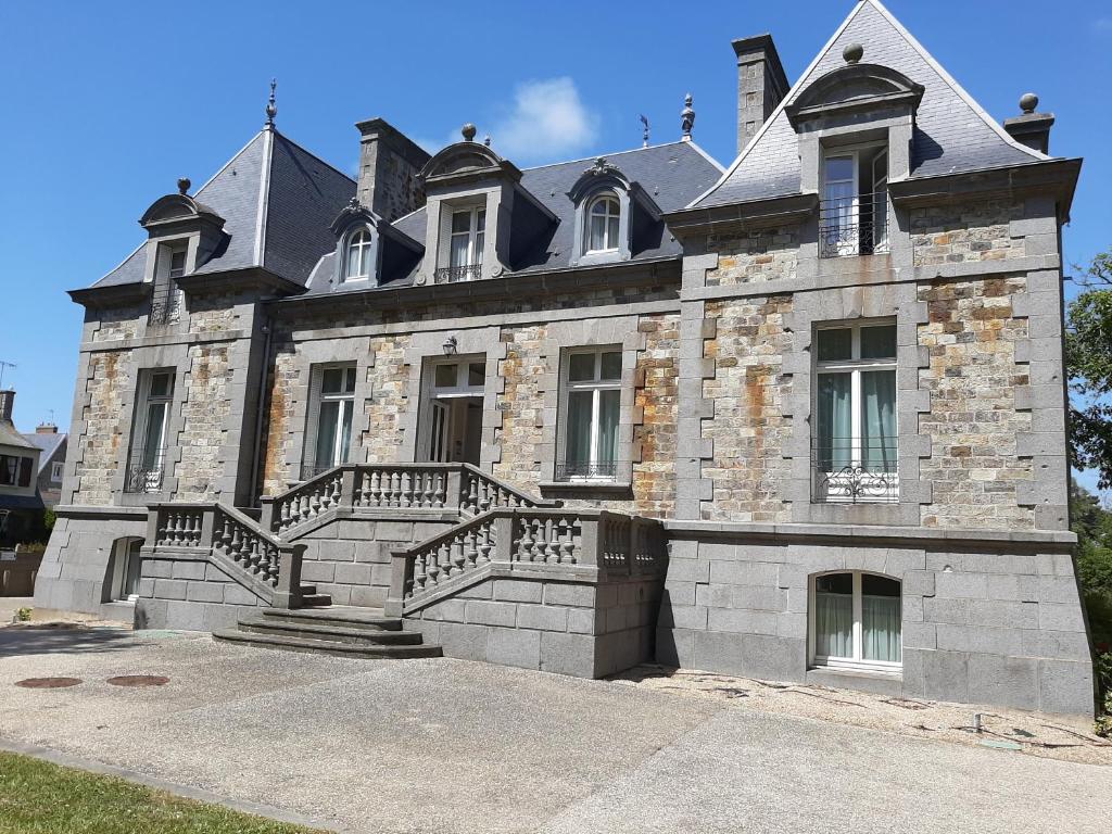 圣马洛Manoir Le Castel & Villa Beaumaris的一座大型石头建筑,前面设有楼梯