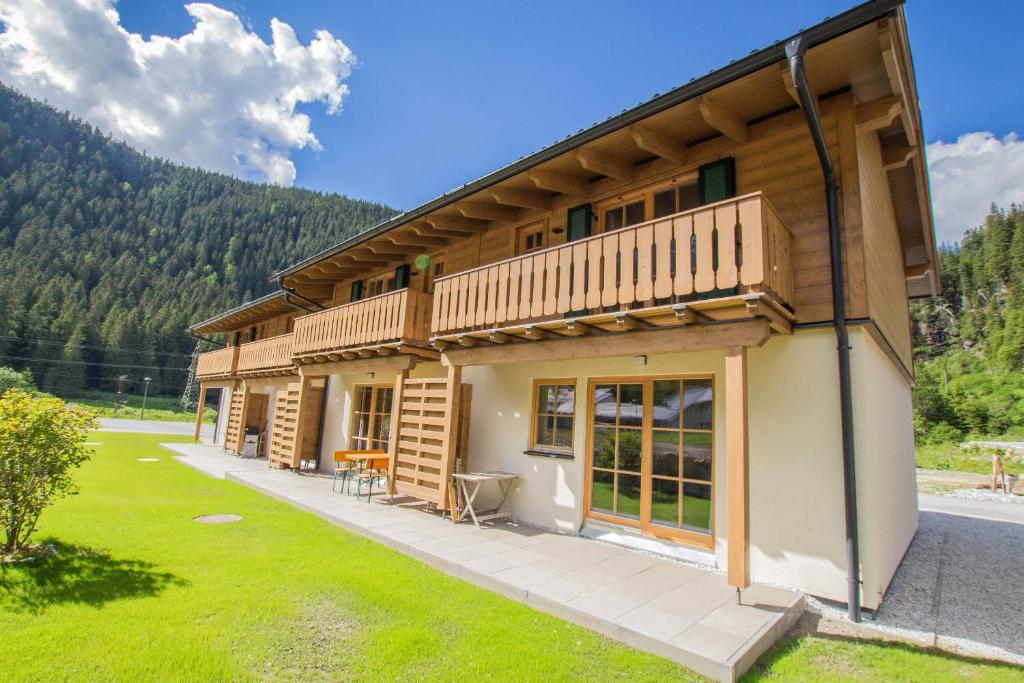 恩吉尔波登Tauerndorf Enzingerboden Ski in&out - Steinbock Lodges的带阳台和庭院的木屋