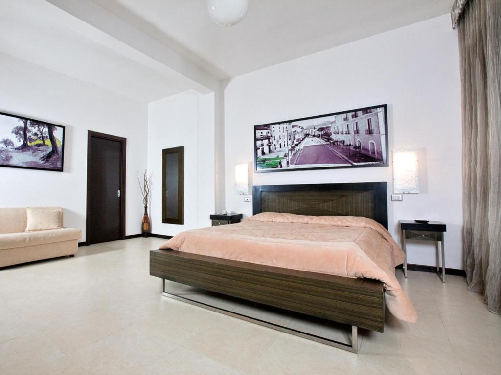 埃博利格拉齐亚埃博利酒店的卧室配有一张床铺,墙上配有电视