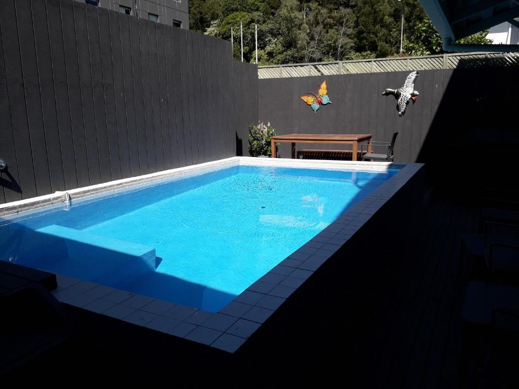 罗托鲁瓦Lake Lodge Motel Rotorua的一个带木桌和长凳的蓝色游泳池