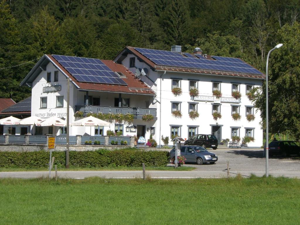 林德伯格Zur Alten Dampfsäge - Gasthaus-Pension Weber的一座大型白色建筑,屋顶上设有太阳能电池板