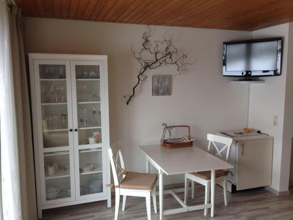 霍伊塞尔恩Schwarzwaldhut的一间设有桌子和墙上电视的用餐室