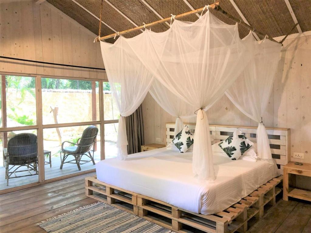 帕罗林Palm Forest Palolem的一间卧室配有一张带蚊帐的床