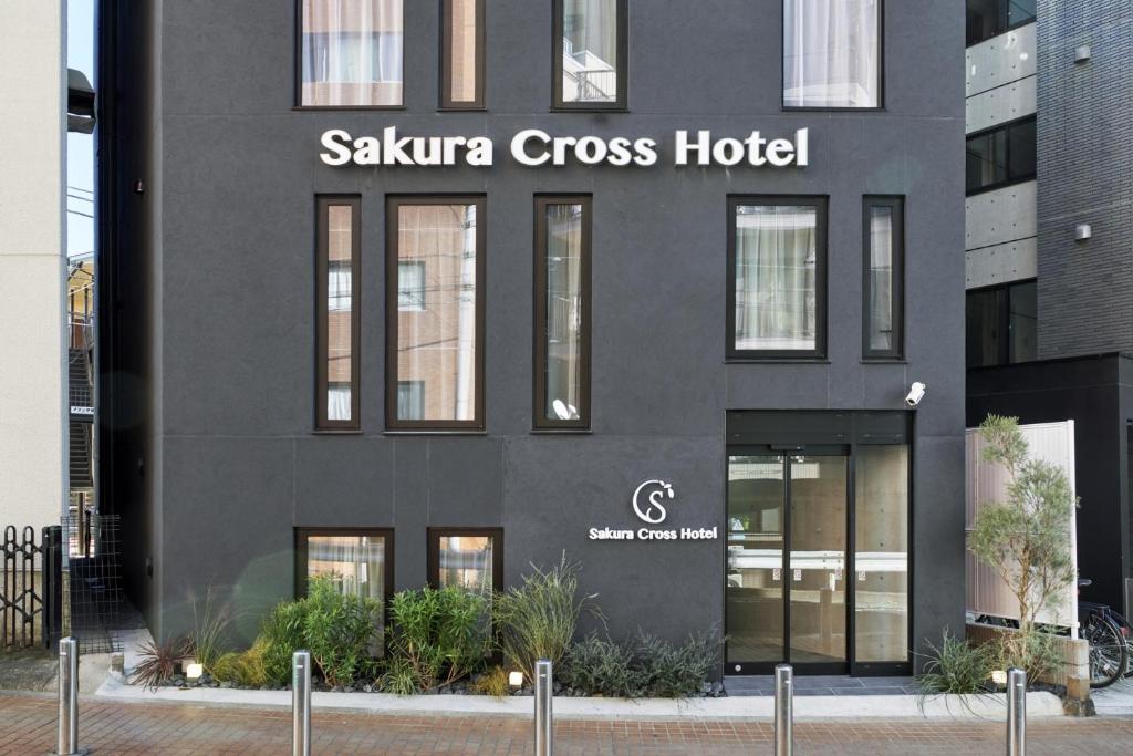 东京Sakura Cross Hotel Shinjuku East Annex的一座黑色建筑,设有桑塔阿纳十字架
