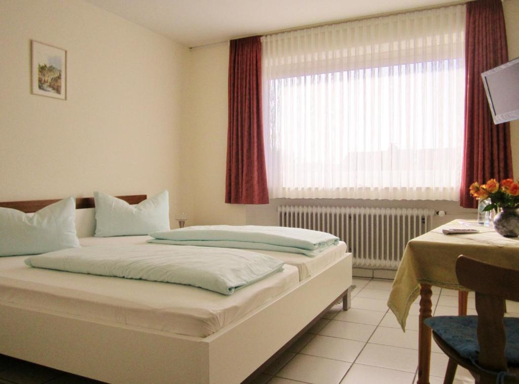 蒙绍哈格尔鲁酒店的一间卧室配有一张床、一张桌子和一个窗户。