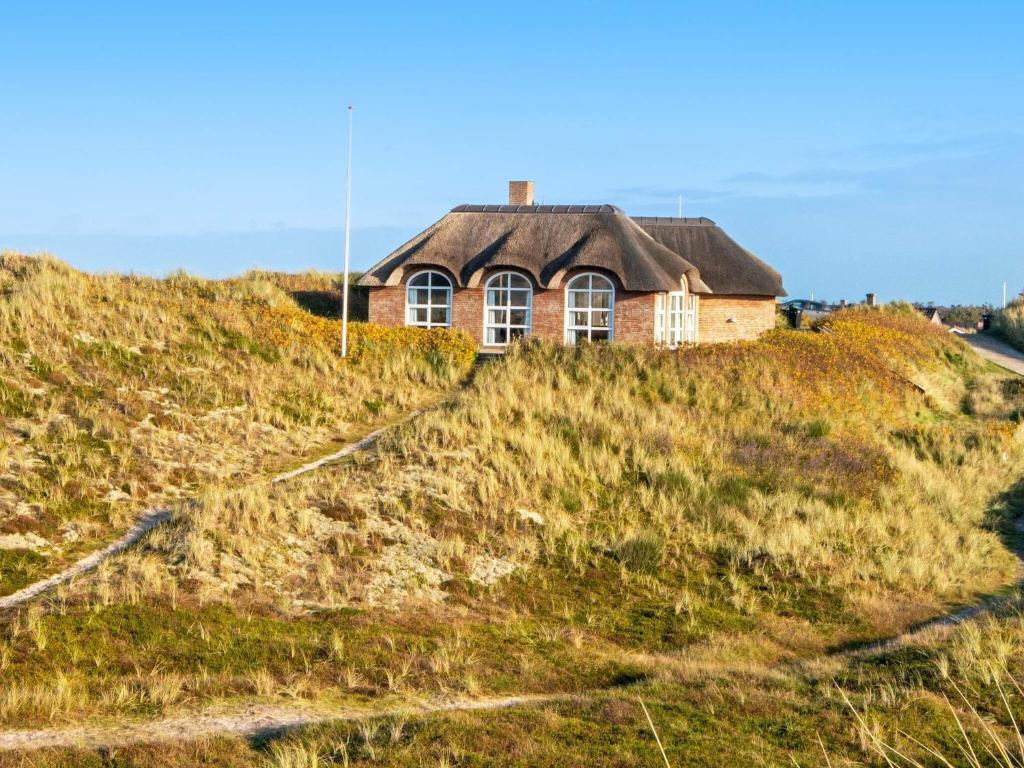 森讷维6 person holiday home in Ringk bing的坐在草山顶上的房子