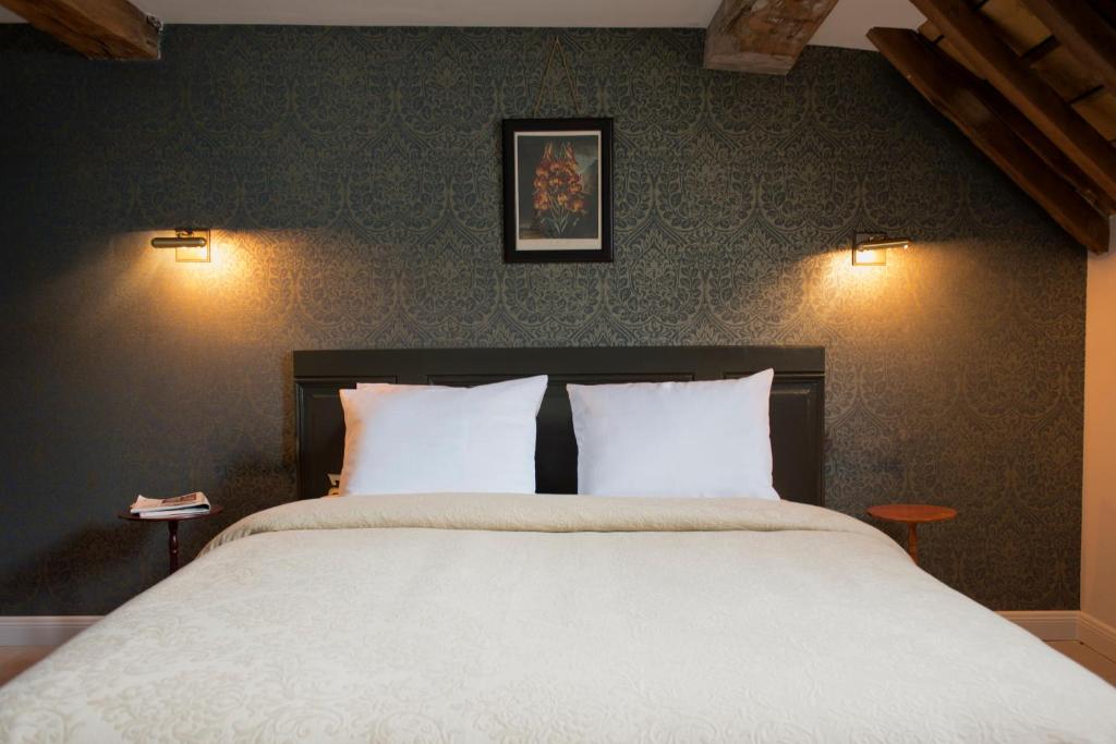 马斯特里赫特圣马丁雅各精品酒店的一间卧室配有一张带两个白色枕头的大床