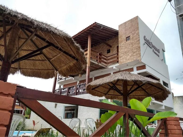 塔曼达雷热带海岸酒店的前面有两把伞的建筑