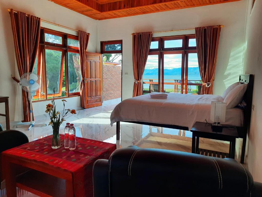 图克图克Juma cottages的卧室配有床、桌子和窗户。