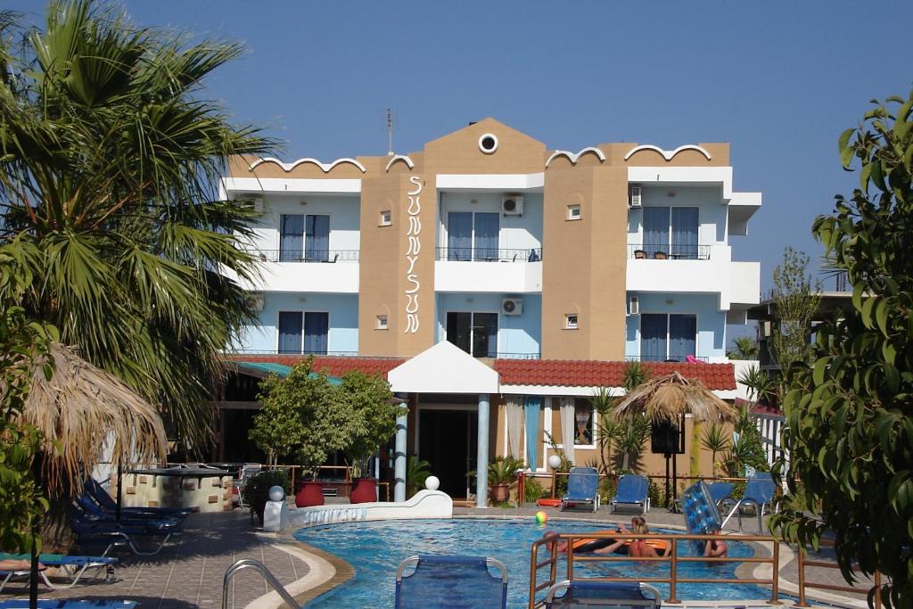 法里拉基艳阳一室公寓酒店的大楼前设有游泳池的酒店