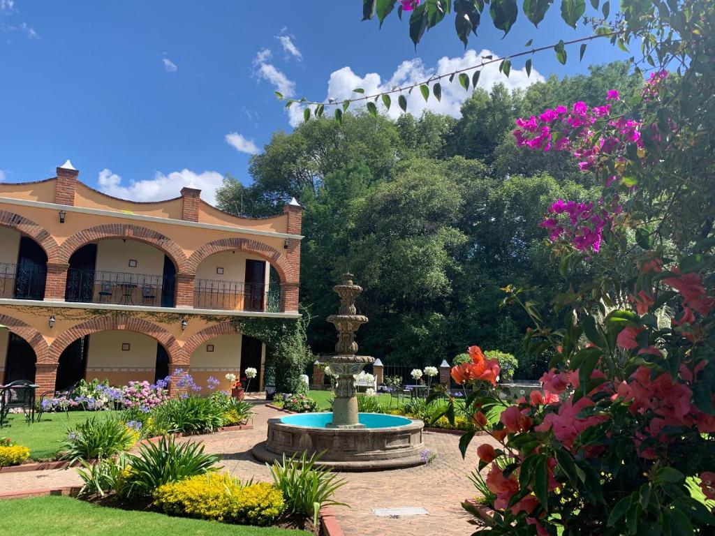 瓦斯卡坎波里尔华斯卡酒店的一座花园,在一座建筑前方有一个喷泉