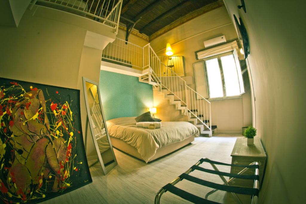 那不勒斯I Visconti的一间卧室设有双层床和螺旋楼梯。