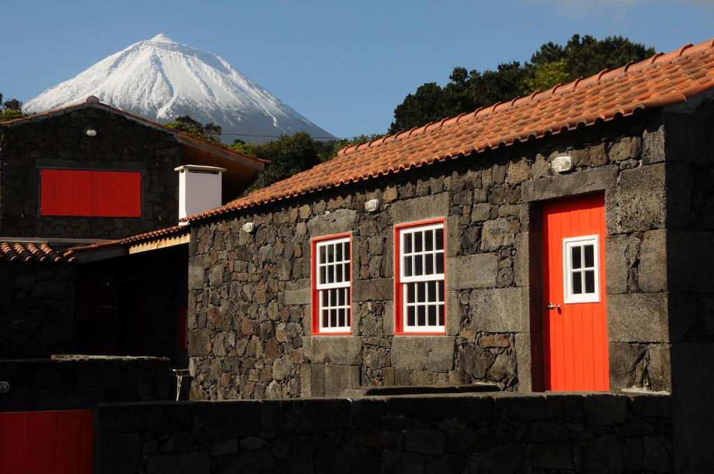 圣罗克杜皮库Casas das Portas do Mar e das Portas do Sol的一座有红门和雪覆盖的山的建筑