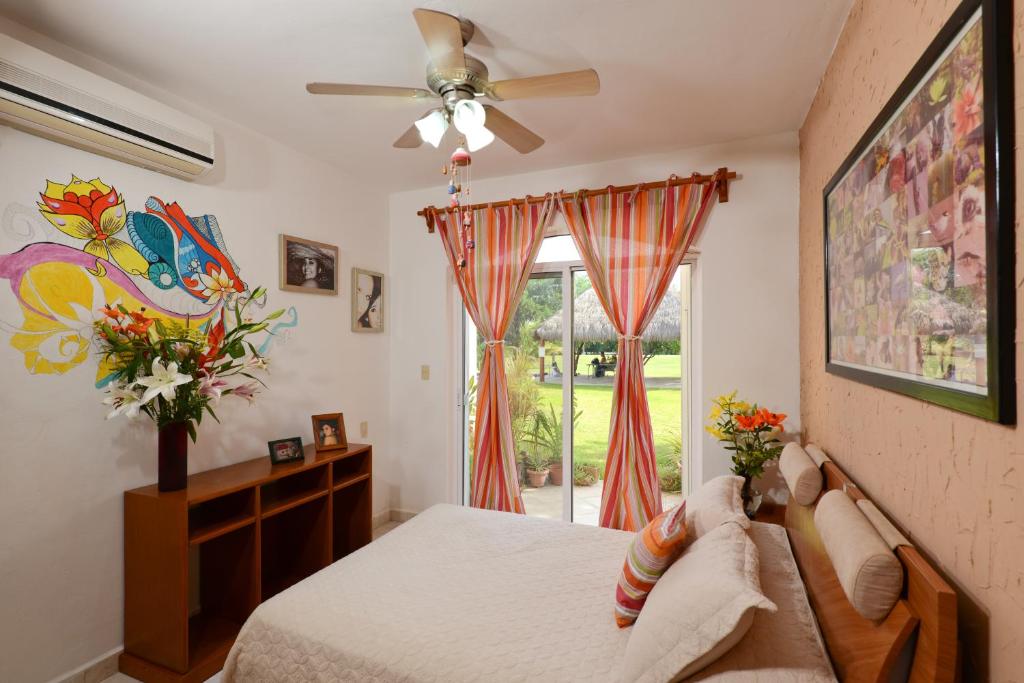 阿文图拉斯港妈妈之家住宿加早餐酒店的一间卧室配有一张带吊扇和窗户的床。