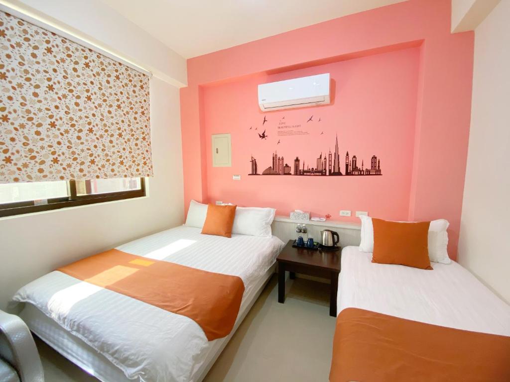 金宁乡杨家民宿 的配有粉红色墙壁的客房内的两张床