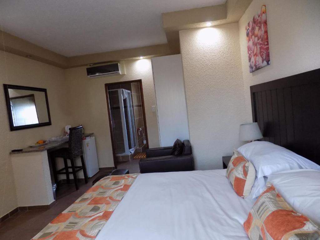 马盖特Margate Beach Lodge的卧室配有一张白色大床和一张书桌