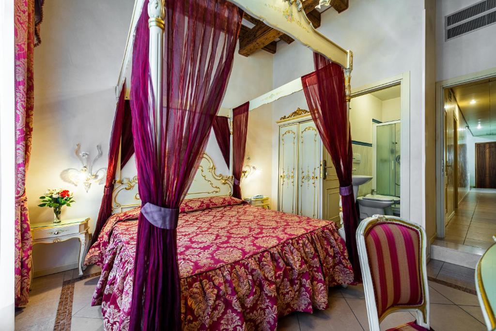 威尼斯埃尔凡高酒店的一间卧室设有天蓬床和一间浴室。