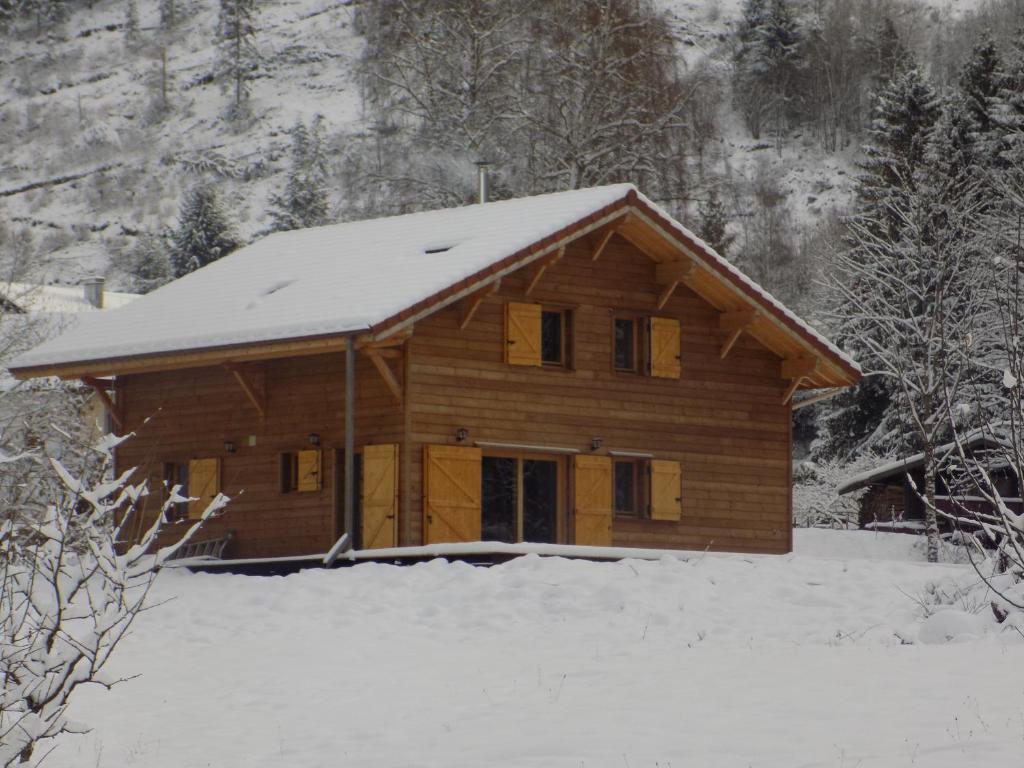 摩泽尔河畔圣莫里斯CHALET DES CHARBONNIERS AVEC ETANG的木屋,上面有雪