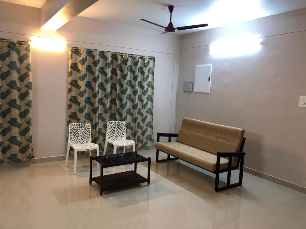 特里凡得琅Nachiyar Suites的一间等待室,配有两把椅子和一张沙发
