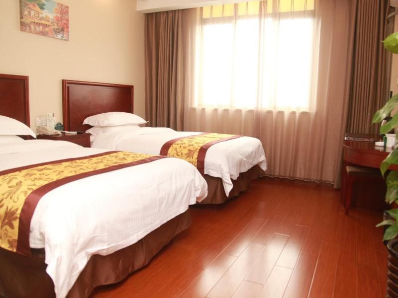 上海格林豪泰上海闵行区浦江镇江月路地铁站商务酒店的酒店客房设有两张床和窗户。