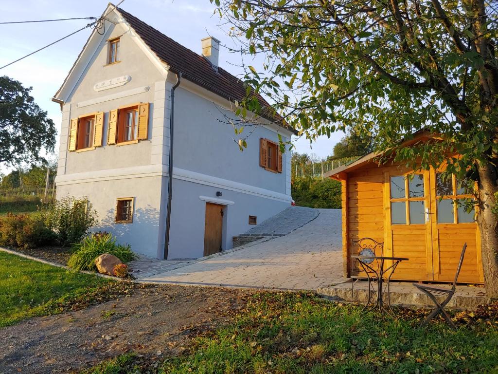 巴德瓦尔特斯多夫kleine Reblaus的一间白色的小房子,有一个黄色的棚子