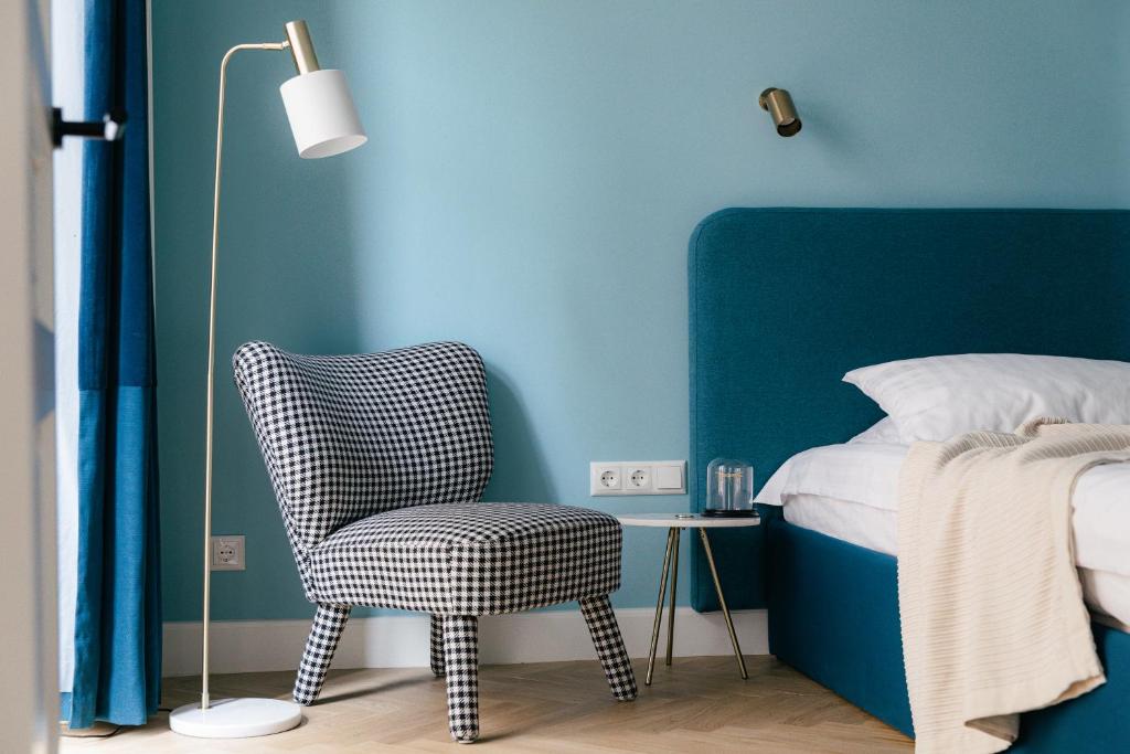 里加MIRO Rooms French - quiet chic, free private parking的一间卧室配有椅子和蓝色的墙壁