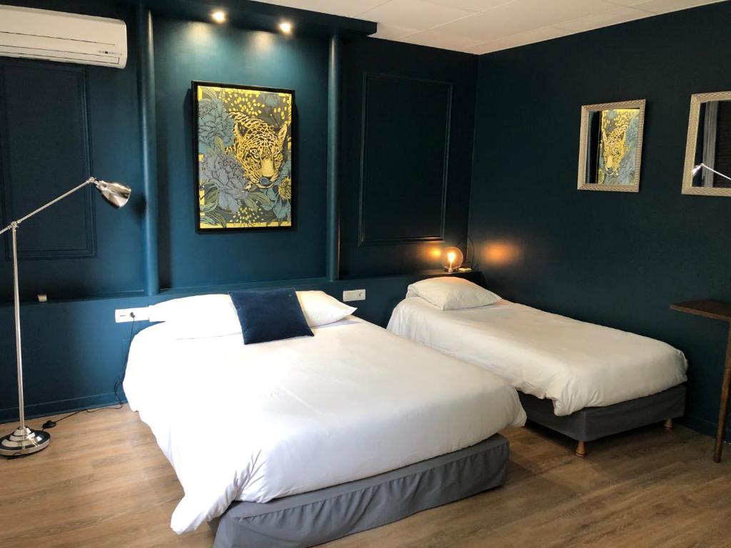 坦耶尔米塔格杏酒之家酒店的蓝色墙壁客房的两张床