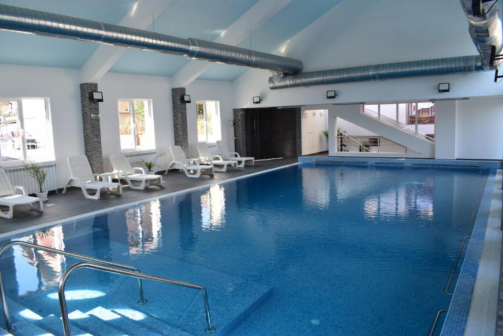 沃尔舍茨Tintyava Balneohotel的一座带白色椅子的大型游泳池