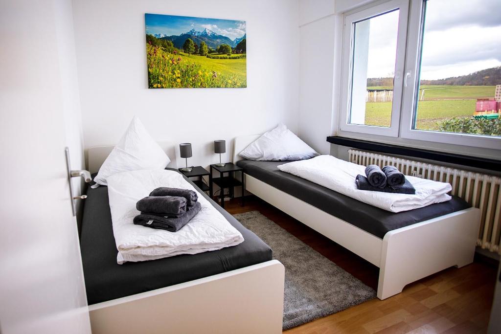 BüsingenSchöne 3-Zimmerwohnung mit WLAN的客房设有两张床和窗户。