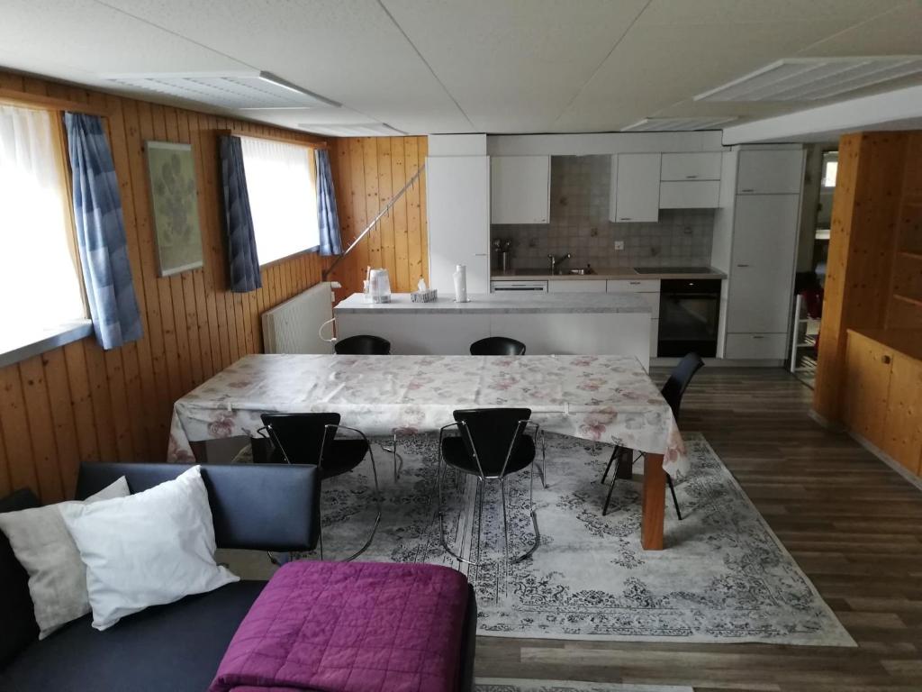 施普吕根Suretta2的一间带桌椅的客厅和一间厨房