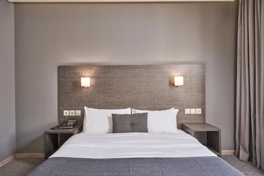 帕特雷地中海酒店的一间卧室配有一张带2个床头柜的大床